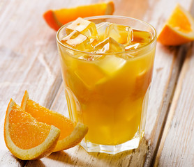 Orange juice  with  fresh fruits on a  wooden background