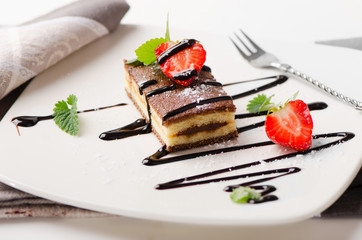 Cake with chocolate and berries on a white plate