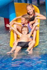Fototapeta na wymiar three little kids playing in the swimming pool