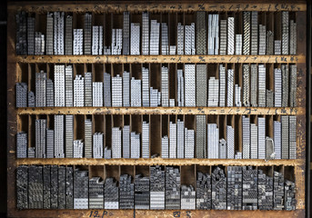 Printing press letter blocks in a wooden shelf