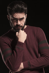 Handsome young man looking down while thinking