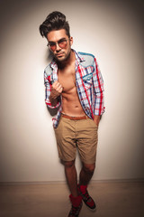 fashion man pulling his shirt while looking at the camera.