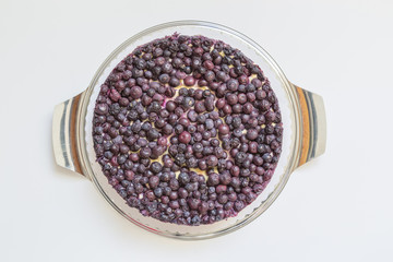Käsekuchen mit Blaubeeren auf Holzbrett vor weissem Hintergrund