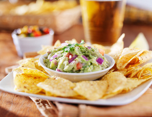 mexican guacamole with tortilla chips and beer
