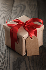 rustic gift box with red ribbon bow and empty tag