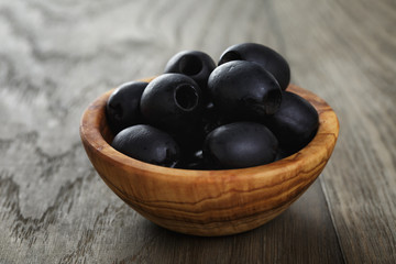 black olives from can in bowl on table