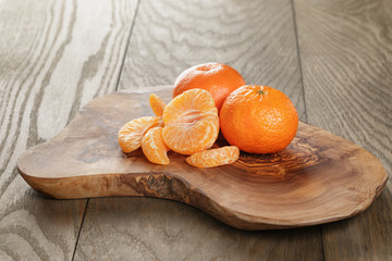 ripe tangerines on olive board