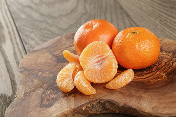 ripe tangerines on olive board