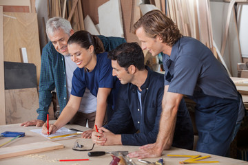 Carpenters Working On Blueprint