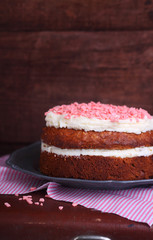 Banana cake with nuts and cream decorated with pink drops