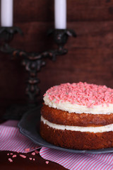 Banana cake with nuts and cream decorated with pink drops