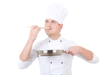 young man in chef uniform tasting something isolated on white