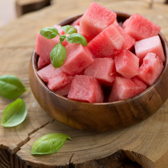 Close-up of a wooden bowl with watermelon cubes, studio shot