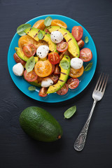 Salad with grilled avocado, tomatoes and mozzarella, above view