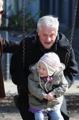 Großvater mit Engeltochter auf dem Spielplatz