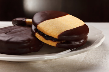 Close-up of sweet biscuits filled with jam and covered with choc