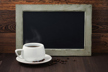 Fototapeta na wymiar black writing board and a cup of coffee with steam