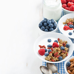 breakfast with granola, yogurt and berries on white