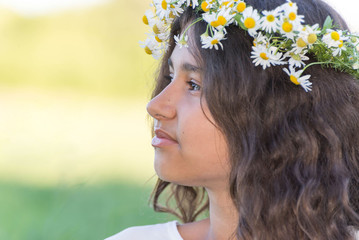 teenage girl with a wreath of daisies on the nature