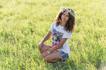 teenage girl with a wreath of daisies on the nature