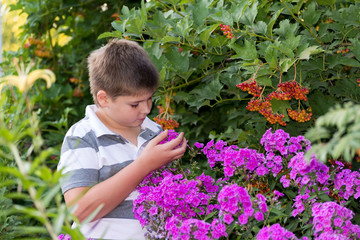 Teen boy about flowers in  garden