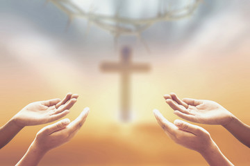 Family worship concept: Praying over blurred crown of thorns and the cross on a autumn sunset background