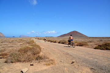 Fototapeta na wymiar excursionistas en bicicleta en la isla graciosa, lanzarote