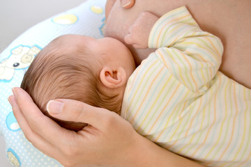 The woman nurses the baby. Breastfeeding