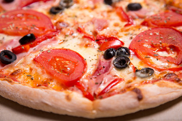 Delicious Italian pizza with ham, tomatoes and olives