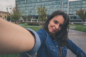 Pretty girl taking a selfie in the city streets