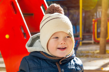 Cute kid om playground in autumn