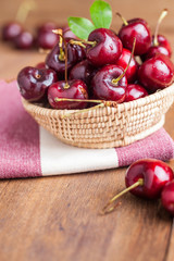 Many fresh cherries in bamboo basket