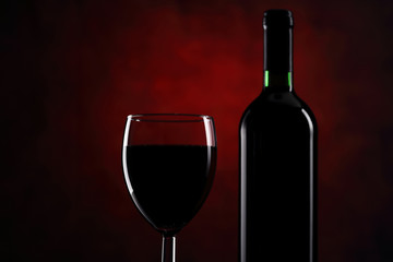 Glass with red wine and bottle