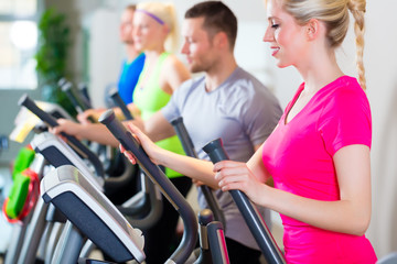 Men and women on treadmill in gym