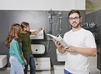 Sales clerk looking catalog at wc and plumbing store