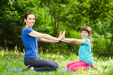 Mother and daughter exercising in park