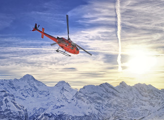 Fototapeta na wymiar Red helicopter at swiss alps near Jungfrau mountain