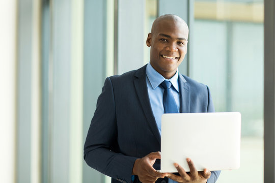 african businessman holding laptop