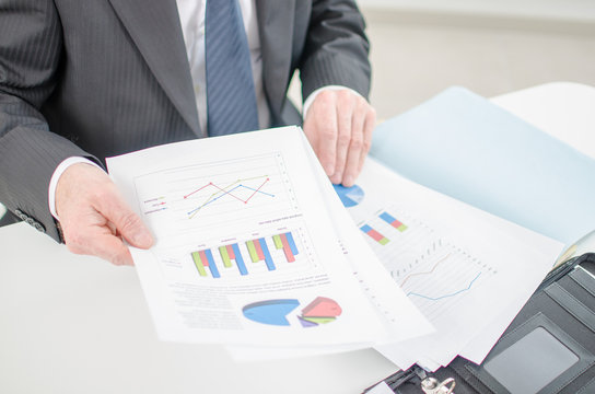 Businessman checking a file with financial graphs