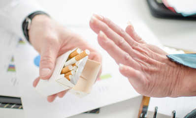 View of a woman's hand refusing cigarette
