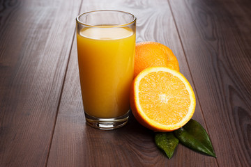 fresh orange and glass with juice on the table