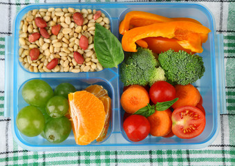 Tasty vegetarian food in plastic box on green wooden table