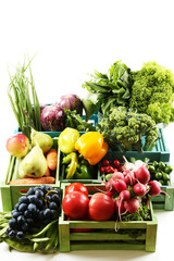 Fresh organic vegetables and fruits in wooden boxes, isolated