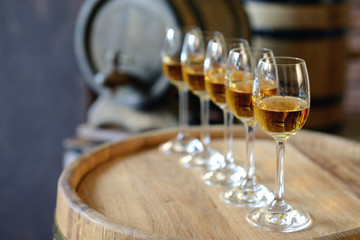 Glasses of wine in cellar with old barrels