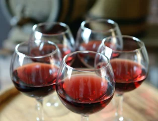 Fotobehang Glasses of wine in cellar with old barrels © Africa Studio