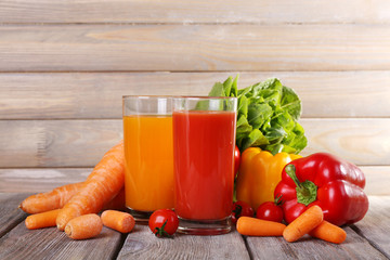 Carrot and tomato juice in glasses and fresh vegetables