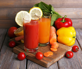 Carrot and tomato juice in glasses and fresh vegetables
