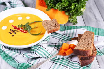 Pumpkin soup in white plate and pumpkin slice
