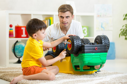 child boy and his father repair toy car