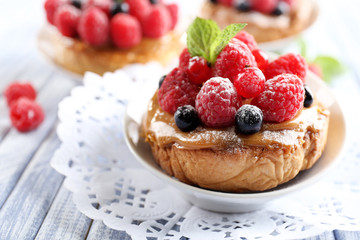 Sweet cakes with berries on table close-up